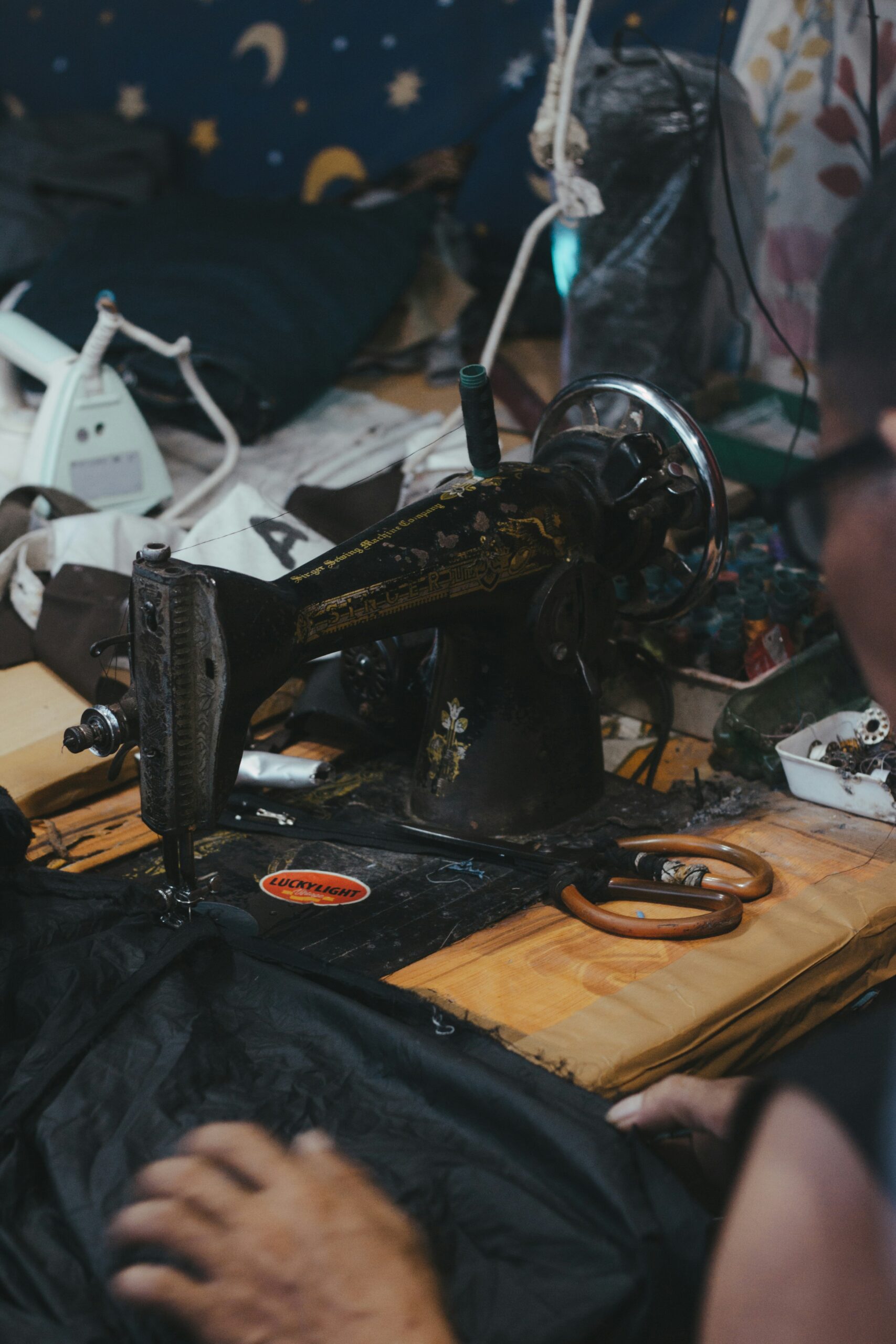 A machinist guiding fabric through an industrial sewing machine