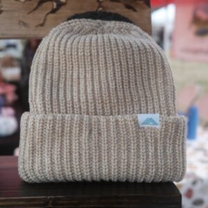 A knitted beanie resting on a wooden table
